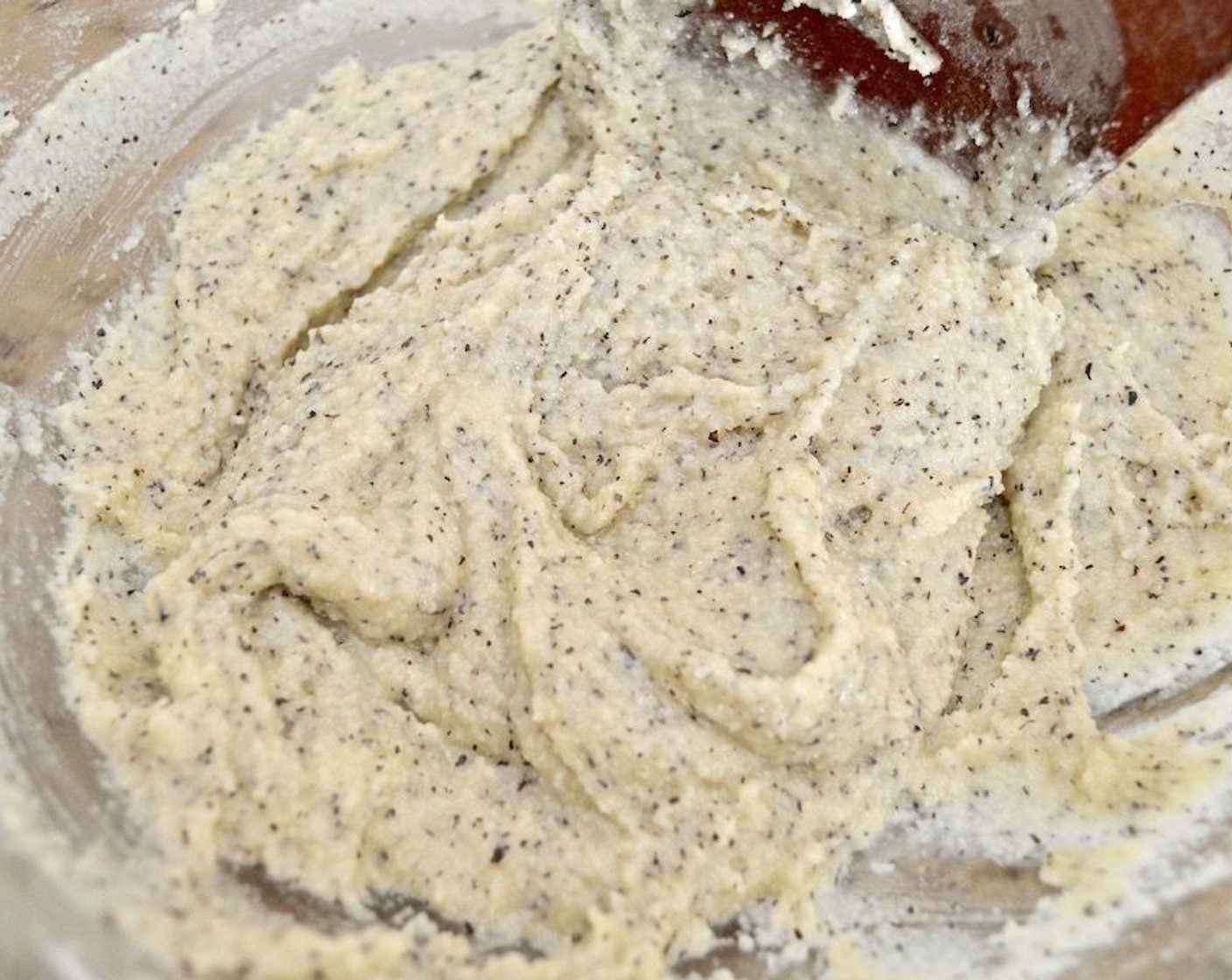 step 4 Then pour in half of the Egg Whites (5) and the Vanilla Extract (1 tsp). Use a spatula to fold and mash the mixture together into a uniform paste. Set the paste aside.