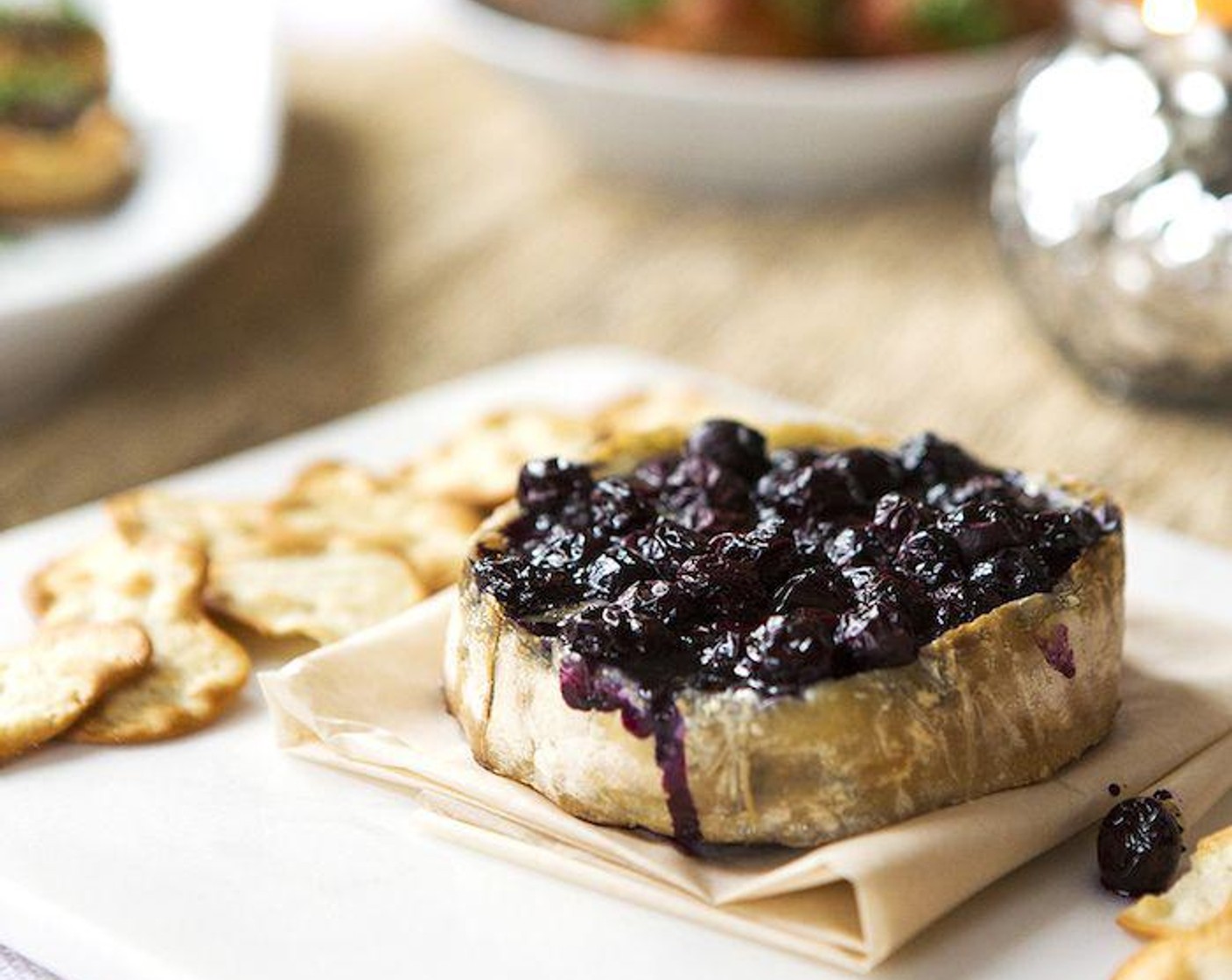 step 5 Carefully place brie to a serving platter and top with blueberry reduction. Serve with your favorite Crackers (to taste). Enjoy!