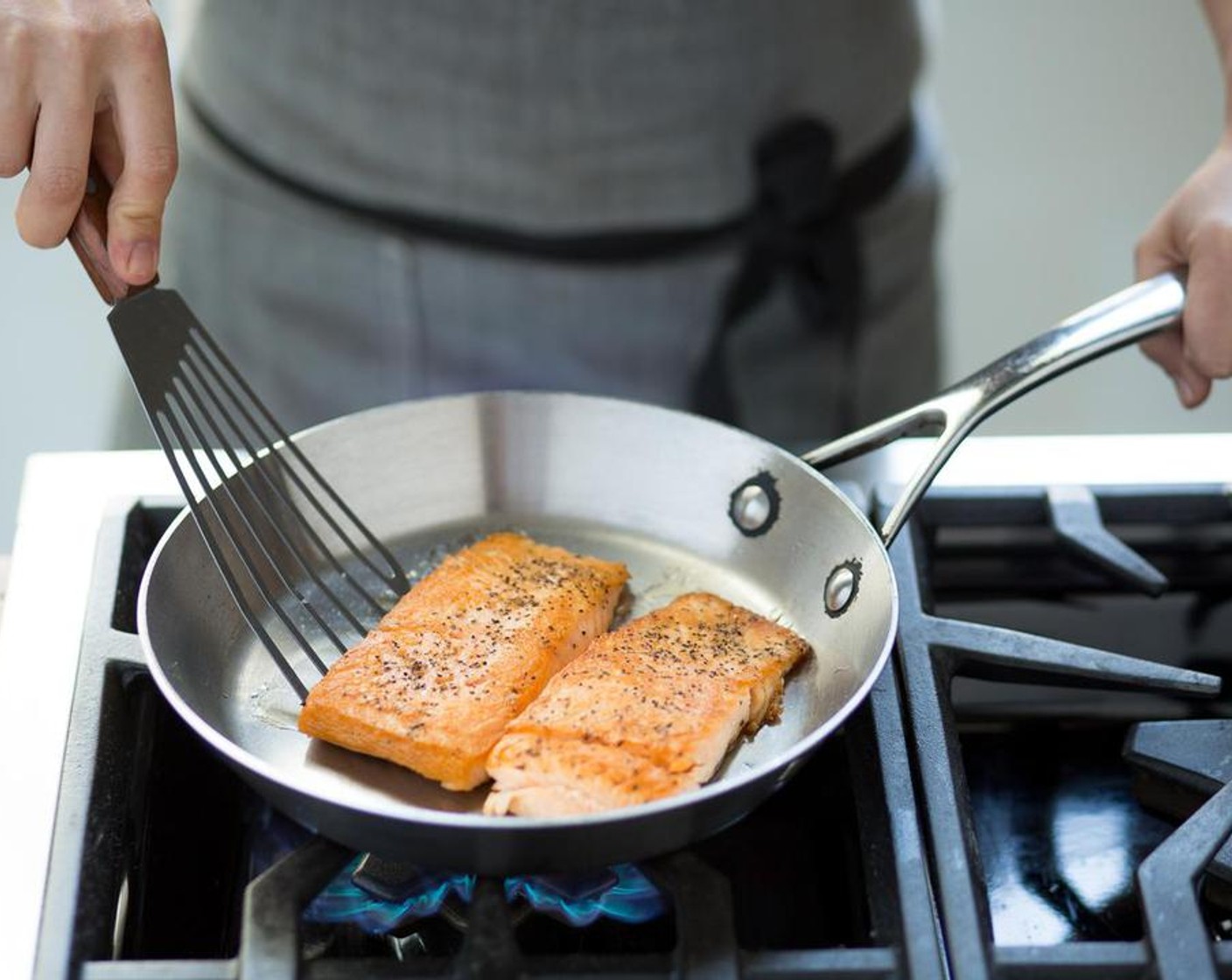 step 6 Heat another medium sauté pan over medium-high heat and add Olive Oil (1 Tbsp). When the oil is hot, place the salmon fillets into the hot pan and sear for 3 minutes on each side; until crispy and cooked through. Remove from heat and set aside for plating.