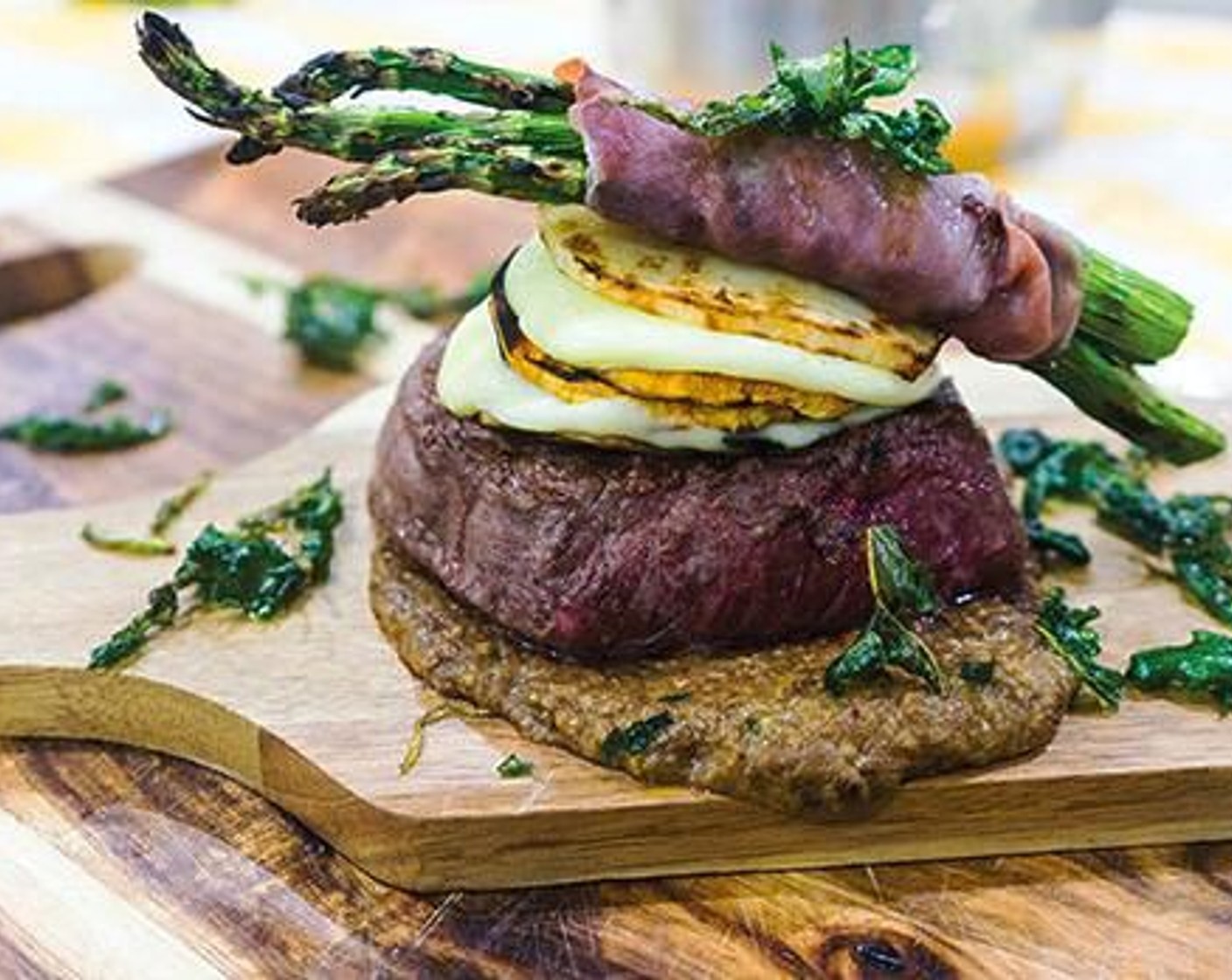 step 11 Place the steak on top of the porcini cream. Top it with the potato stacks and the prosciutto-wrapped asparagus. Serve with the arugula chips and enjoy!