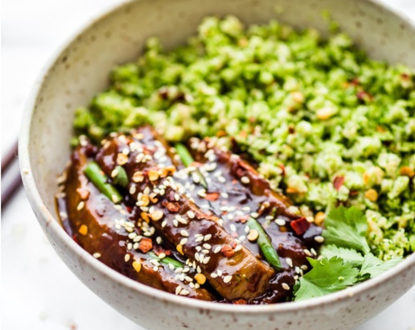 step 8 Add 1/2 cup or more broccoli rice to bowls. Then place beef and sauce on top.Top with the Scallion (1 bunch) and Crushed Red Pepper Flakes (1 tsp)! Add the Sesame Seeds (to taste) and Fresh Cilantro Leaves (to taste) to garnish each bowl.