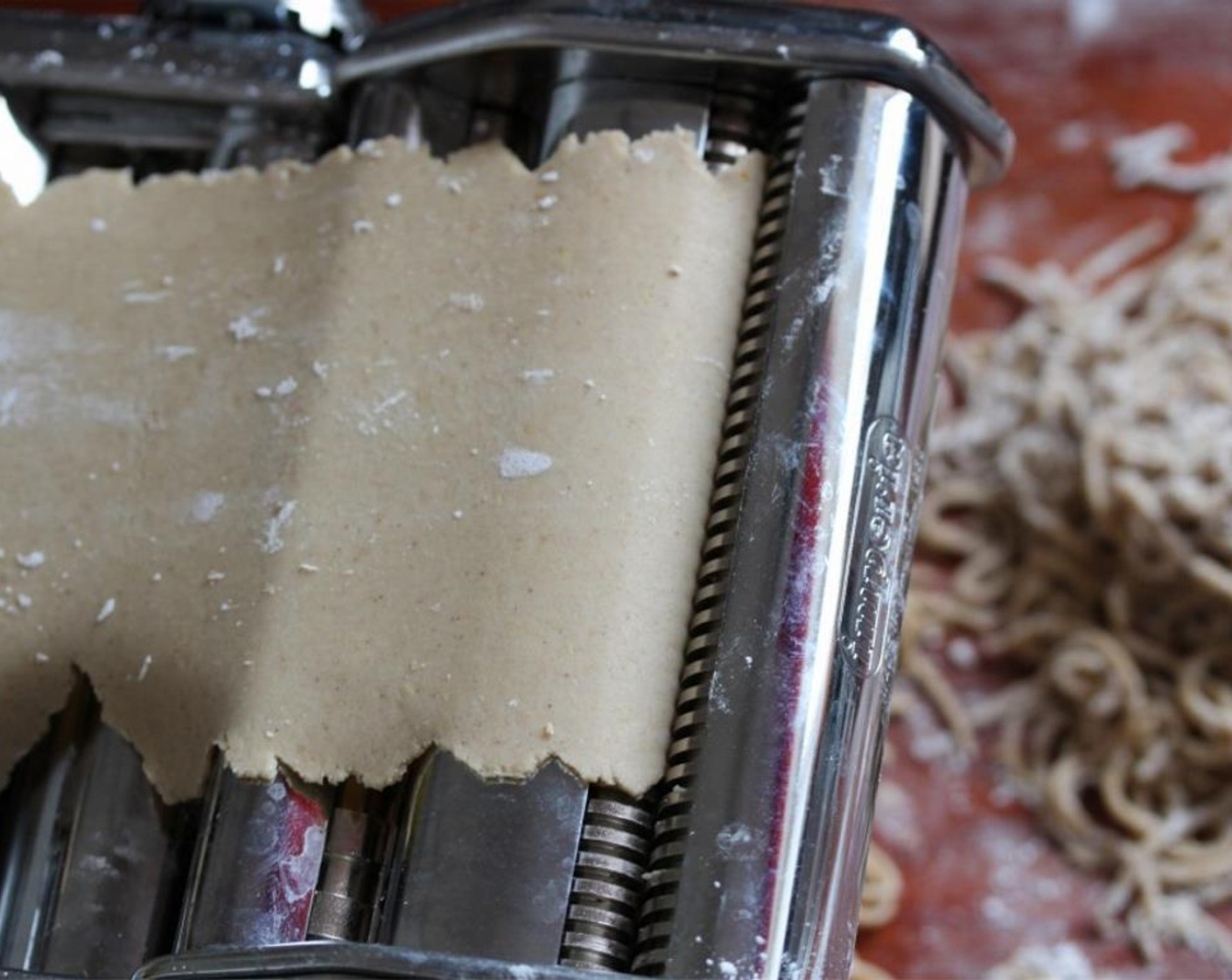 step 4 Divide the dough in half and place one piece on a floured work surface. Press until flat and then feed through the pasta machine 10 times on the widest setting, folding it neatly between each pass.