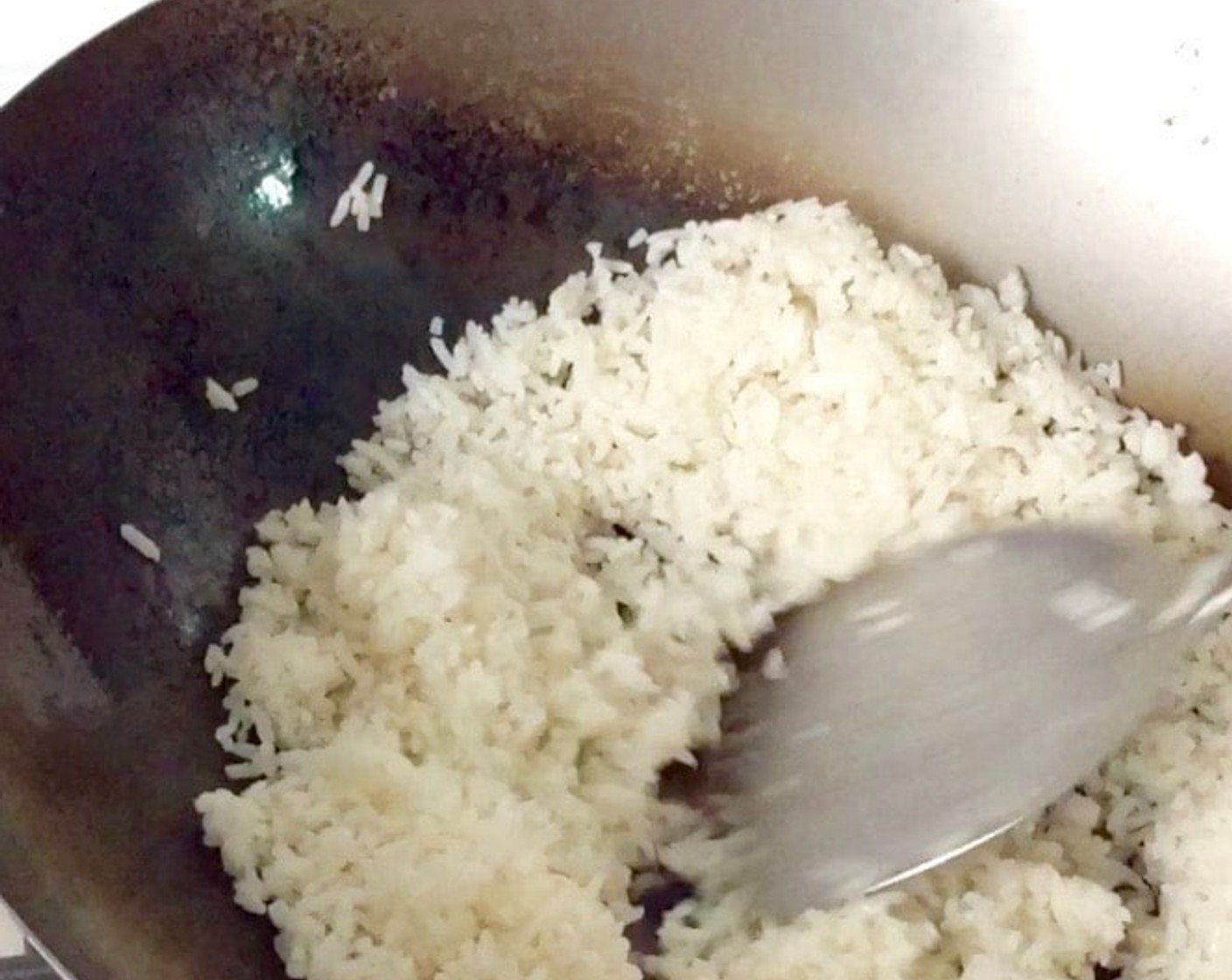 step 9 Add in the cooked rice. Fry the rice for about 1-2 minutes until heated through. Use the back of the ladle to gently tap and break up rice or any clumps.