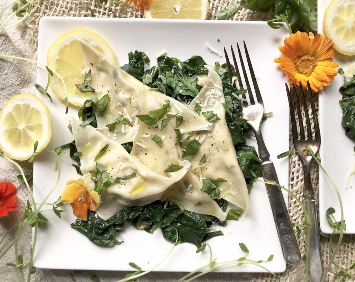 step 7 Divide the spinach mixture among 4 plates. Top evenly with the ravioli, remaining Grated Parmesan Cheese (1 Tbsp), Fresh Basil (2 Tbsp), Freshly Ground Black Pepper (1/4 tsp), and Extra-Virgin Olive Oil (1/2 Tbsp).