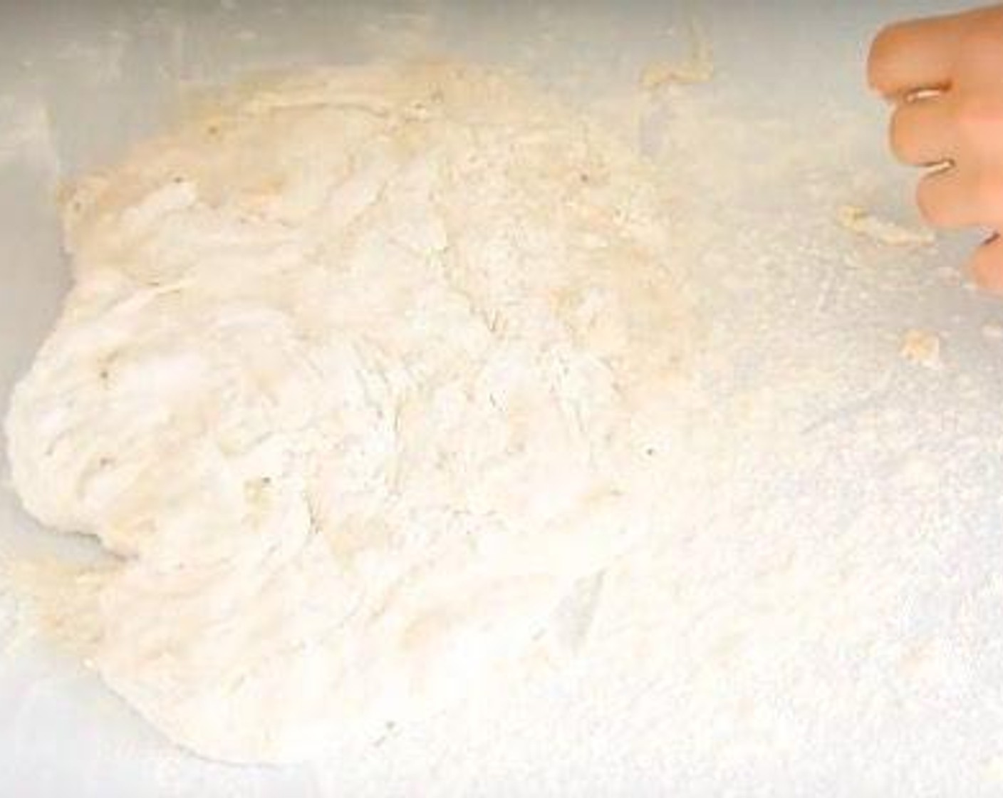 step 2 After 3 hours, the dough will have bubbles and become puffy. Pour it onto a working surface, sprinkle with a couple of tablespoons of flour and shape into a ball using a scraper.