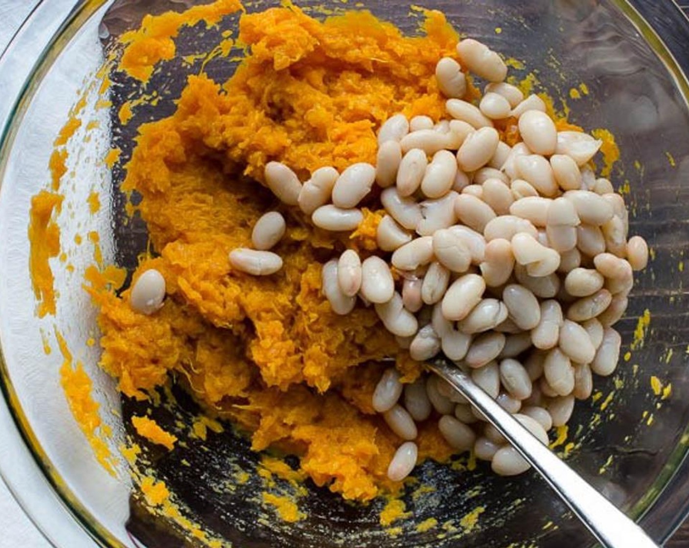 step 3 Remove the skin and transfer the potato flesh to a medium bowl. Mash the potato with the back of a fork. Add the Canned Cannellini White Kidney Beans (2 cups) and mash them into the potato mixture. Set aside.