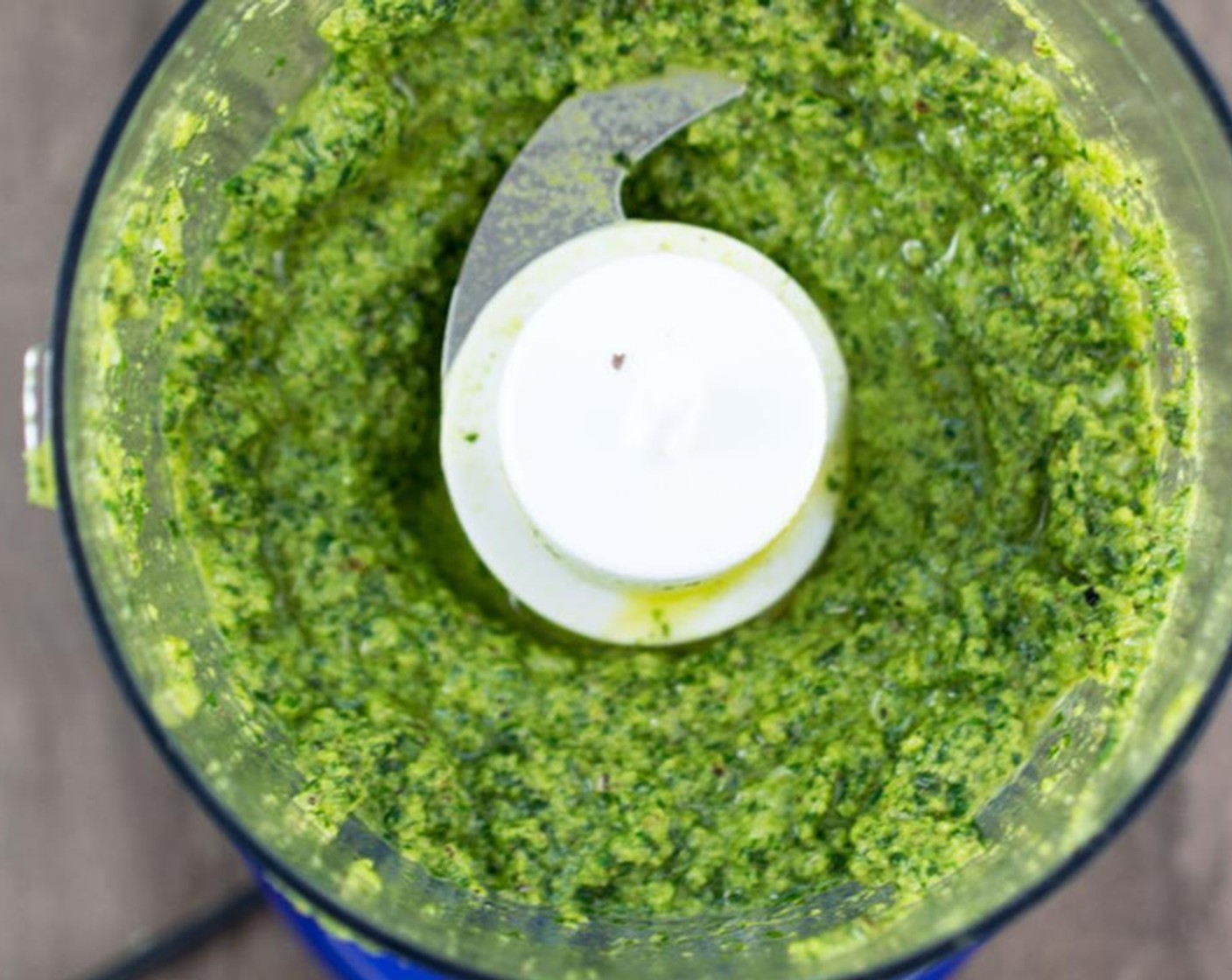 step 4 Add Olive Oil (3/4 cup) in a slow steady stream. If pesto is too thick add in a bit more olive oil. Stir in Parmesan Cheese (1 Tbsp).