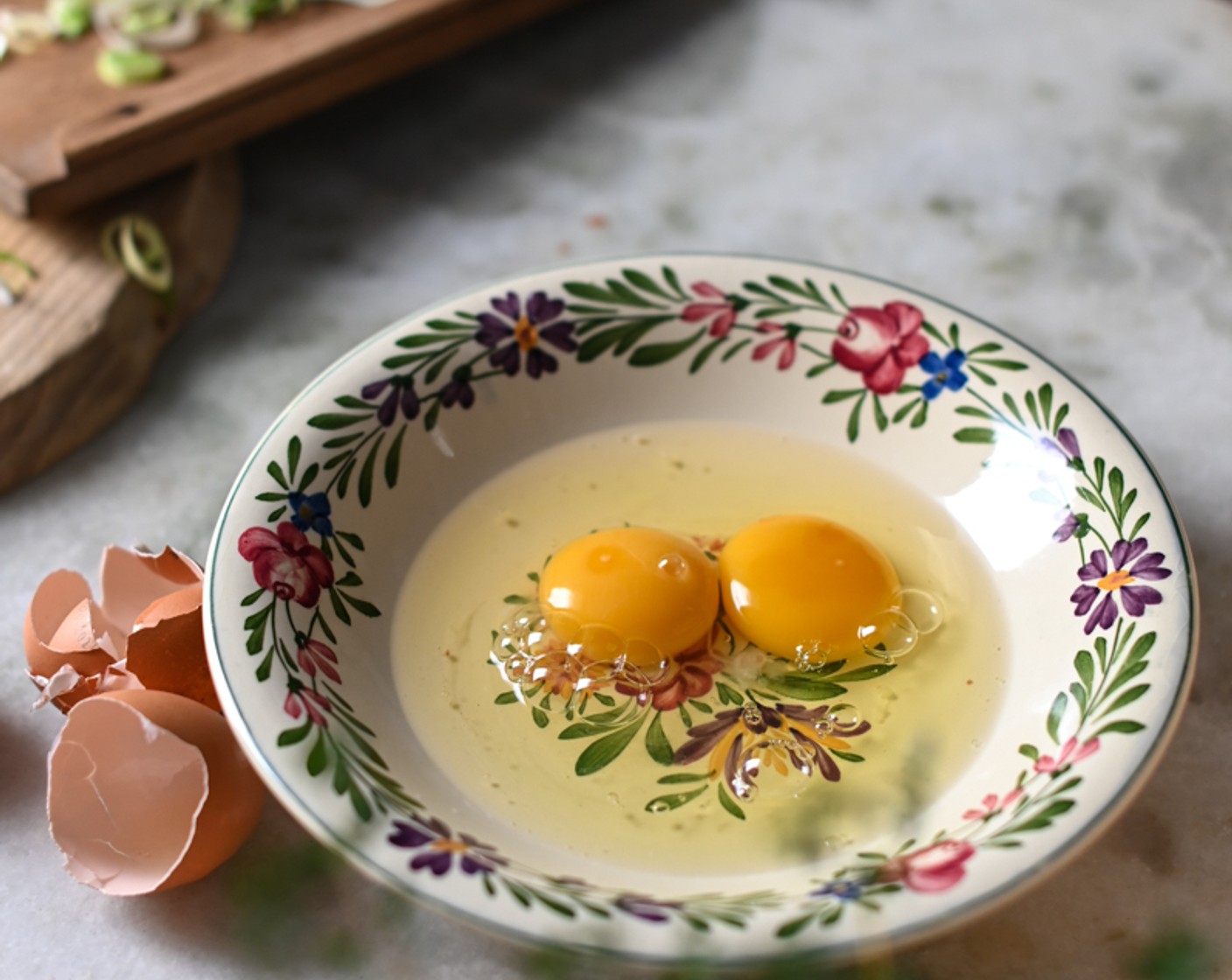 step 3 Sprinkle the Leek (1) and Asparagus (2) and carefully break two Organic Eggs (4) into each ramekin – the yolks need to remain intact.