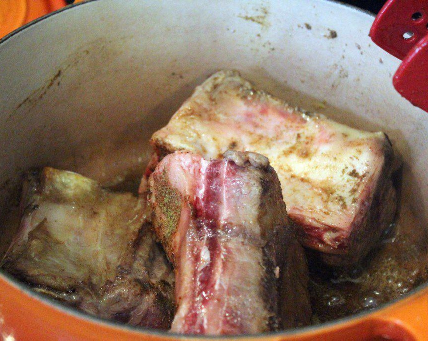 step 5 When the pan is very hot, sear the Beef Short Ribs (4) on all sides, sprinkling them directly with Salt (1 tsp), Ground Cumin (1 tsp), and Chili Powder (1 Tbsp) as you go. As you turn the ribs, let them SIT to get really good and brown.