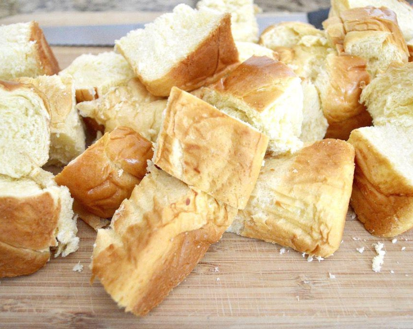 step 1 Take a 9x13-inch baking dish and grease it really well with butter or cooking spray. Add the chunks of  Brioche (1 loaf) to the tray and press it lightly into an even layer.