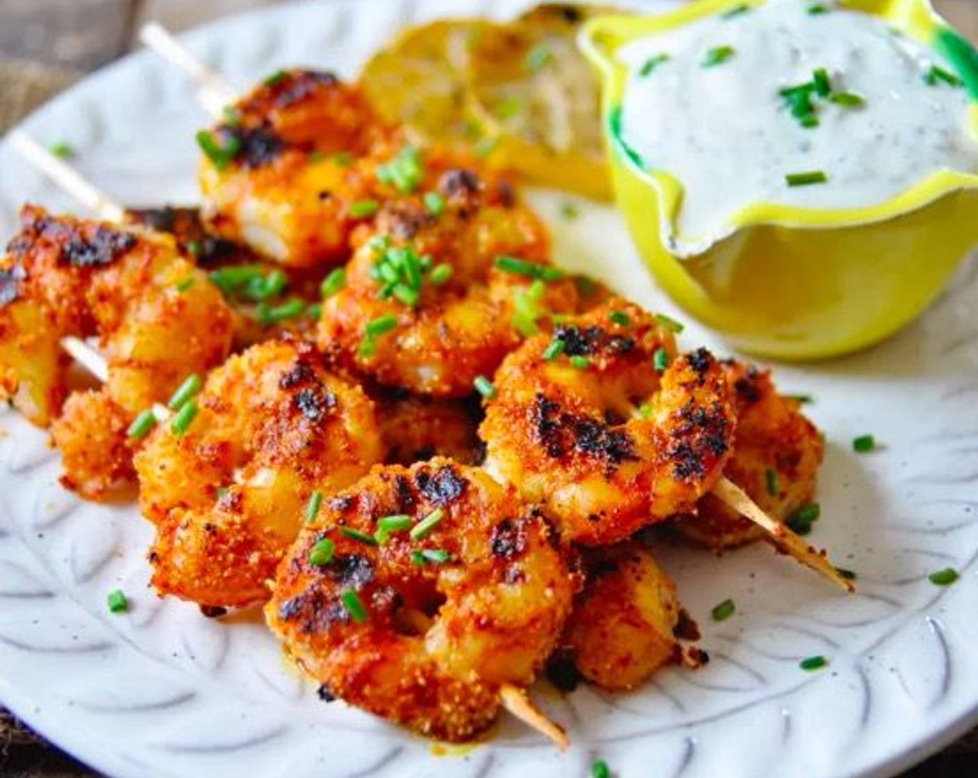 step 9 Add the shrimp kabobs to a plate along with the lemon garlic aioli. Garnish with the grilled lemon slices and Fresh Chives (to taste). Serve and enjoy!