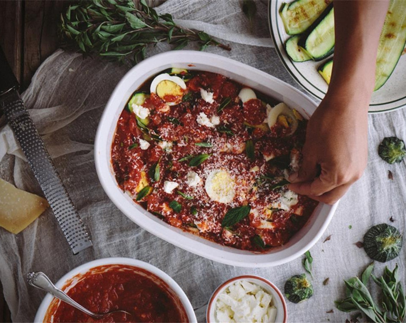 step 13 For the last layer, cover the top with zucchini slices and pour the rest of the tomato sauce over the top. Sprinkle it with the grated parmesan.