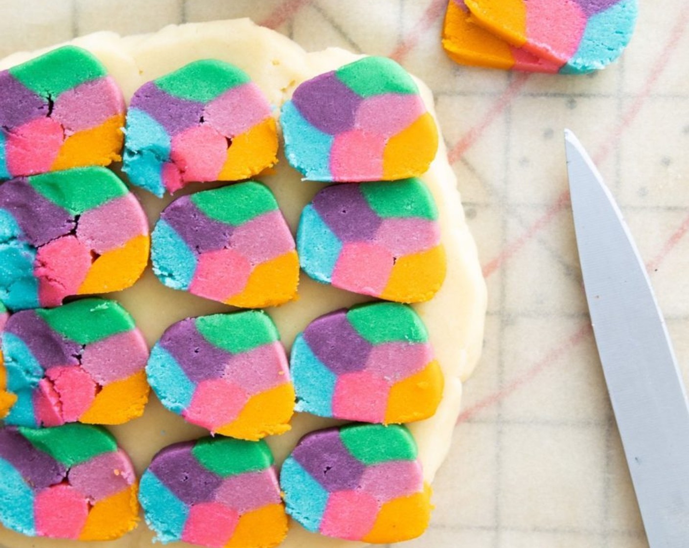 step 10 Slice the colored cookie dough log into 1/8-inch slices and place them on top of the uncolored dough, like tiles. If there are any large gaps between the slabs of colored dough, use the extra dough to fill in the space.