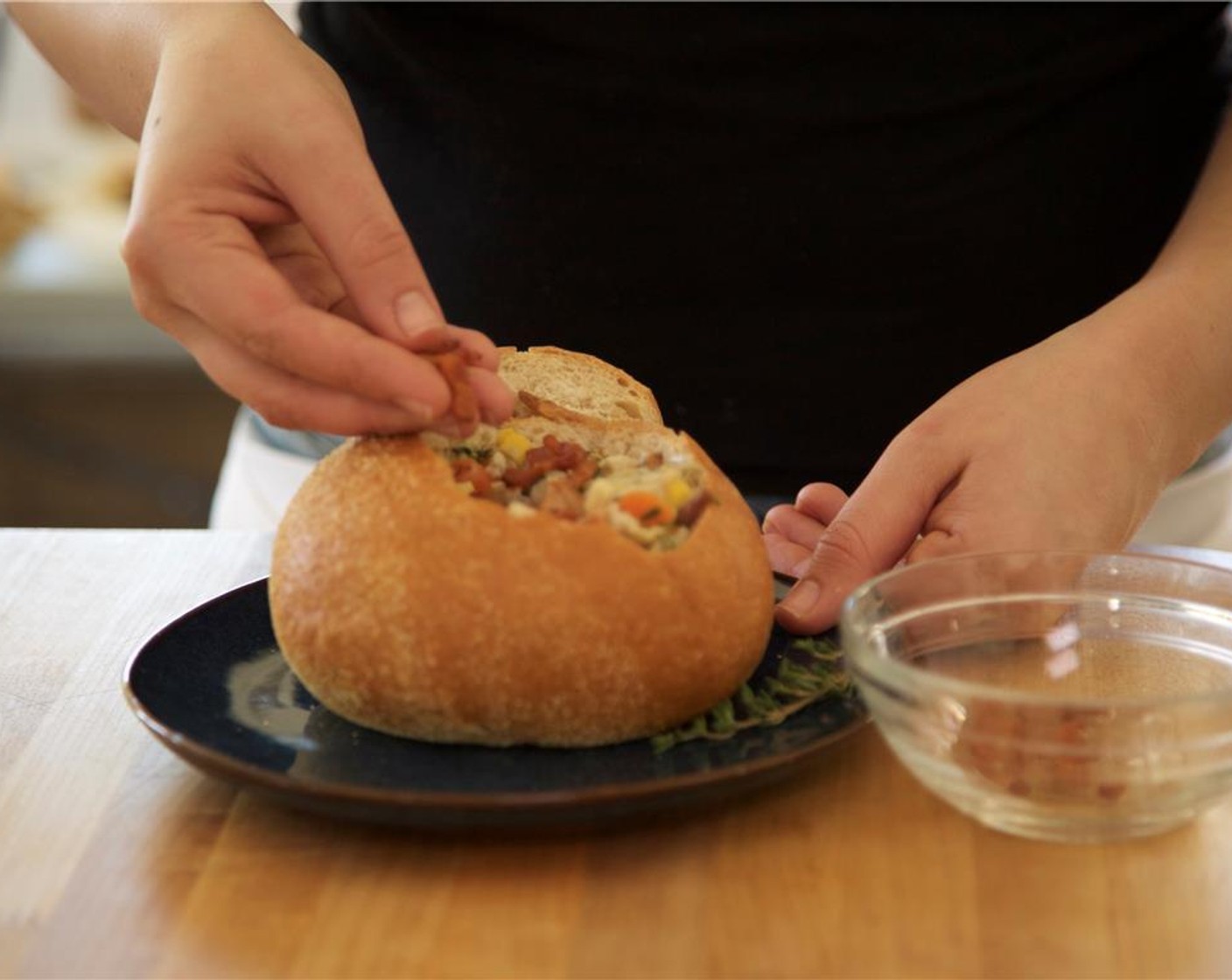 step 15 Place the bread bowls in the center of two plates. Fill the bowls with chowder. Garnish with bacon and remaining thyme.