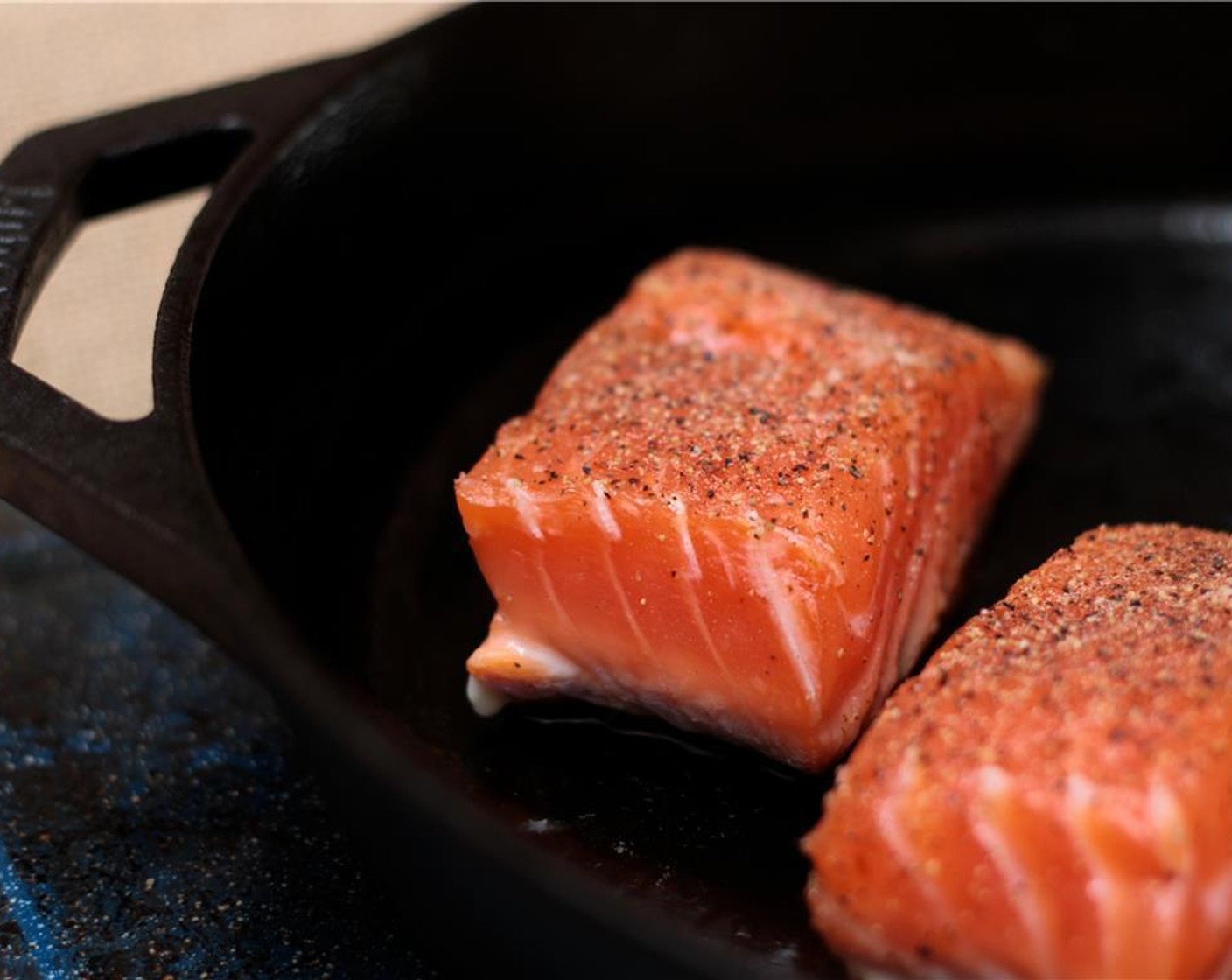 step 4 Heat Olive Oil (1 Tbsp) oil in a Lodge 12-inch cast iron skillet over high heat until hot. Place the salmon, skin side down, in the pan. After about 1 minute, reduce the heat to medium. Cook the fillets another 5 to 8 minutes.