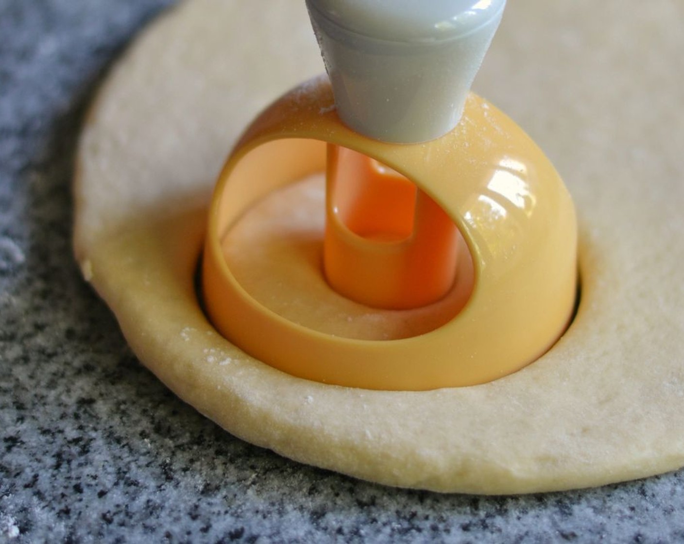 step 4 Roll out dough to around ½ inch / 1.2 cm thick with a rolling pin. Cut out donut shapes with a tool or a cup and a smaller cup. Keep the donut “holes”.