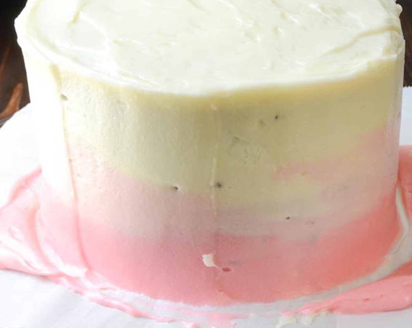 step 15 Use your offset spatula to create the ombre effect. Hold the spatula vertically from top to bottom firmly against the cake and gently turn the cake plate around. This will smush the icing flat against the cake and the different tones will naturally run into each other.