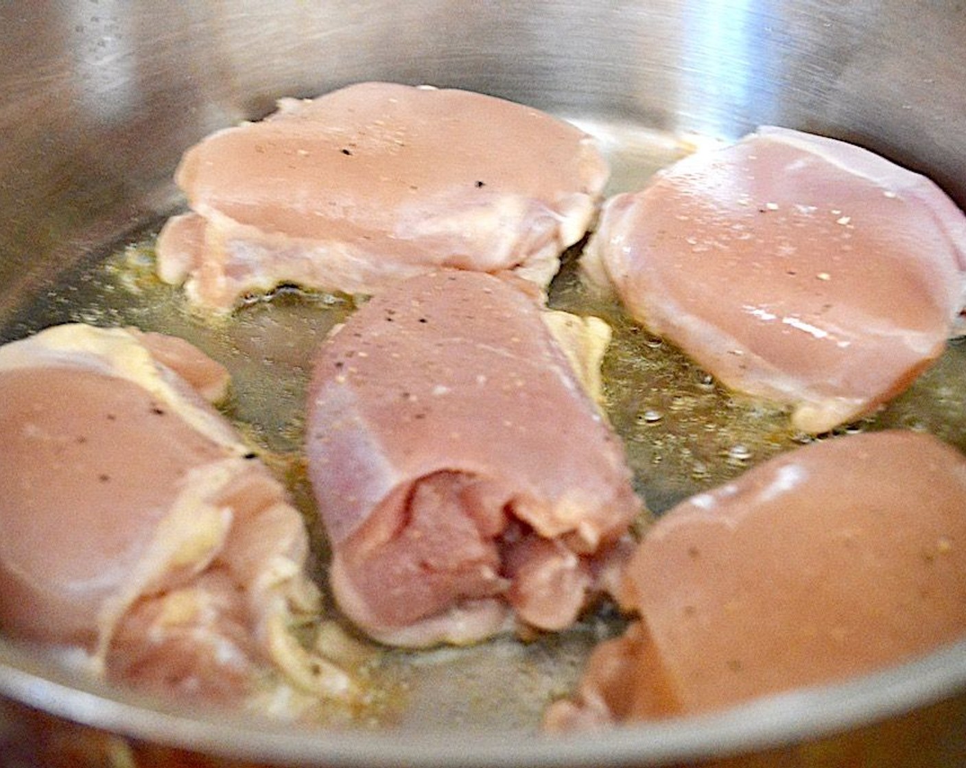 step 2 Heat the Olive Oil (1 dash) in the skillet over medium high heat. While it heats up, generously season the Boneless, Skinless Chicken Thighs (5) on both sides with the Salt (2 pinches), Ground Black Pepper (2 pinches) and McCormick® Garlic Powder (2 pinches). Then brown the chicken for 4 minutes on each side in the skillet and transfer to a plate.