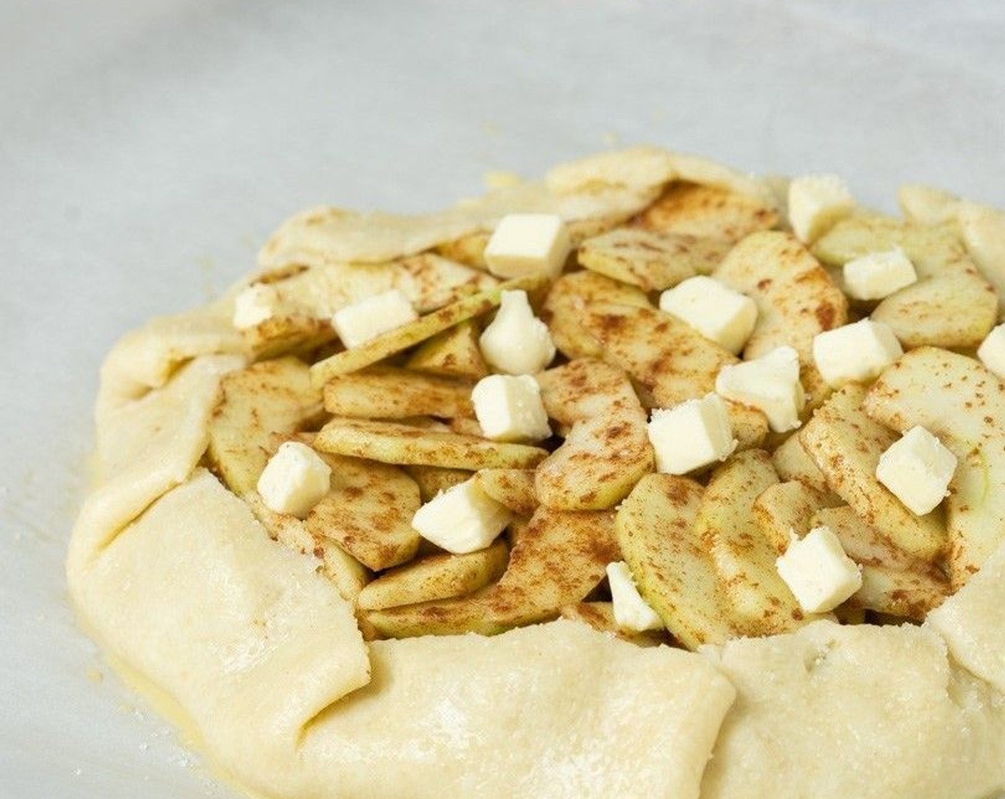 step 11 Sprinkle the apples with dots of Unsalted Butter (2 Tbsp). Brush the pastry with egg wash and sprinkle with Coarse Sugar (to taste) if desired.