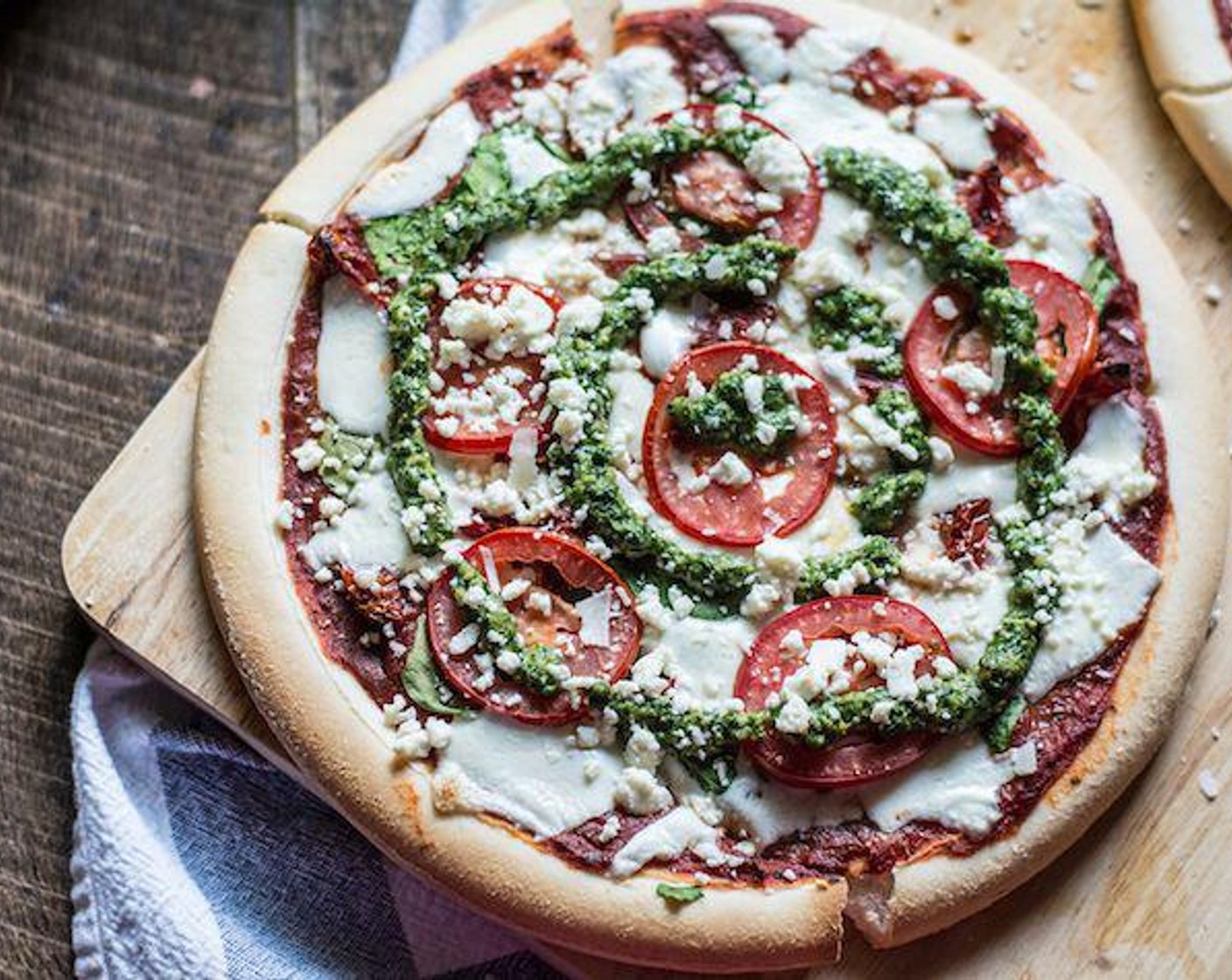 step 4 To assemble pizzas, add homemade pizza sauce to both Gluten-Free Pizza Crusts (2) followed by a single layer of Fresh Spinach (1/2 cup) and Sun-Dried Tomatoes (1/3 cup). Then, top with Fresh Mozzarella Cheese Ball (2/3 cup) and finally layer Roma Tomato (1).