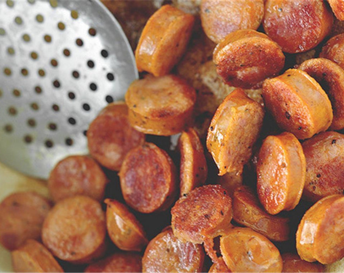 step 2 Heat the Canola Oil (1 Tbsp) in a large heavy duty pot, or dutch oven. Add the Andouille Sausages (455 g) and sauté for 5-7 minutes, until browned. Remove the sausage and transfer to a plate. Set aside.