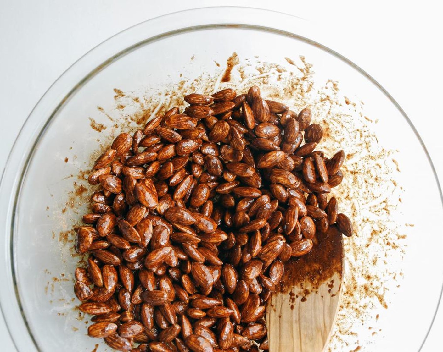 step 2 In a large mixing bowl, add Raw Almonds (3 cups), Pure Maple Syrup (1/4 cup), Vanilla Extract (1/2 Tbsp), Unsweetened Cocoa Powder (1 tsp), Ground Cinnamon (1 tsp), Ground Cardamom (1 tsp), Ground Ginger (1 tsp), Ground Cloves (1/2 tsp), and Ground Black Pepper (1/4 tsp). Mix to coat well.