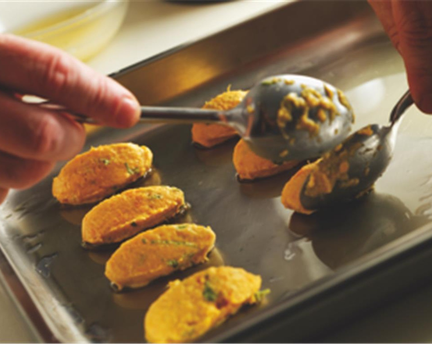 step 5 After an hour, spoon the sweet potato mixture into quenelles. Then place them on an oiled baking tray and bake in the oven for 8 minutes on each side.