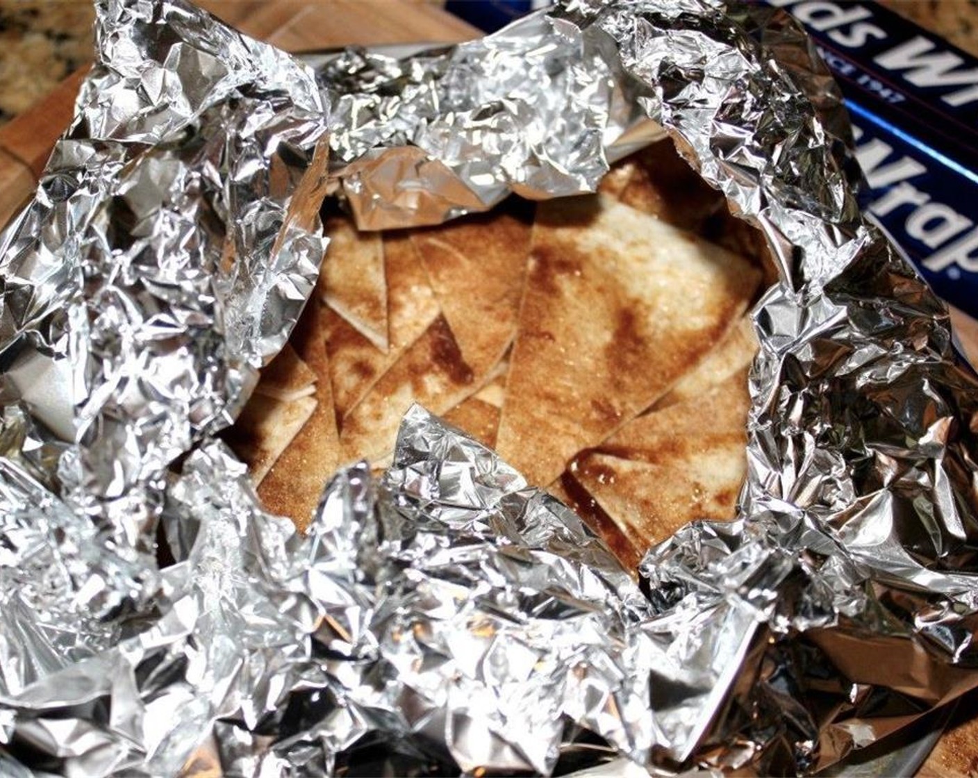 step 12 Place all the wedges into a foil "bowl" and loosely close the foil up. Bake at 400 degrees F (200 degrees C) for about 15 minutes, or until the chips are golden and crispy.