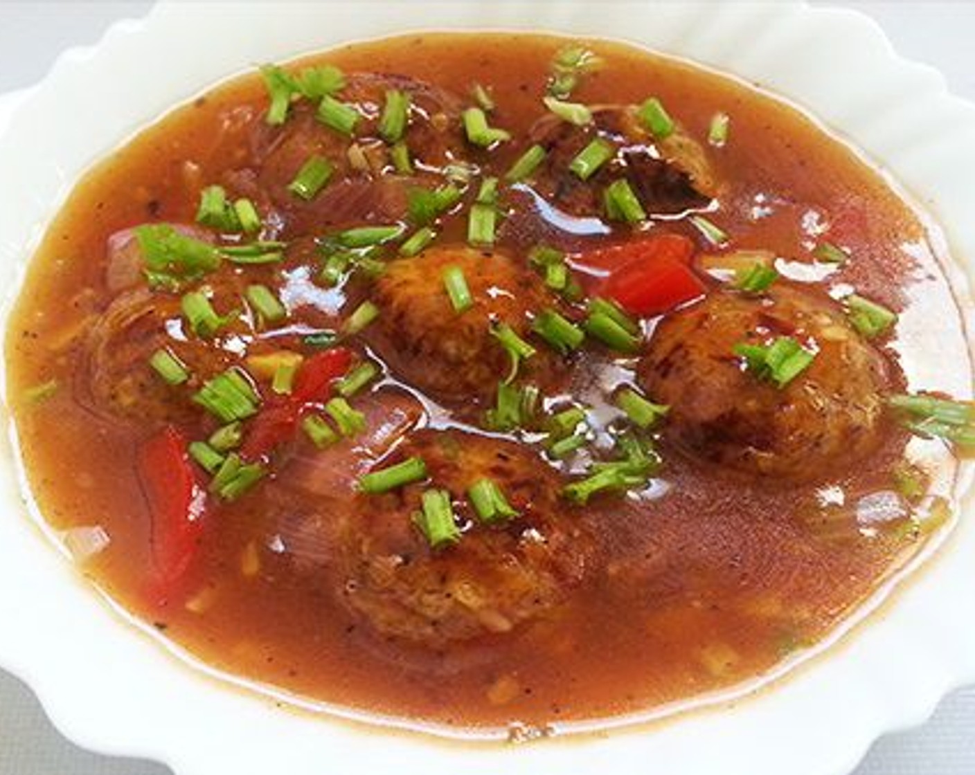 step 10 Now add the fried Manchurian balls and boil for a minute. Switch off the flame and garnish with Scallions (to taste) and serve hot with fried rice, plain basmati rice, roti or naan.