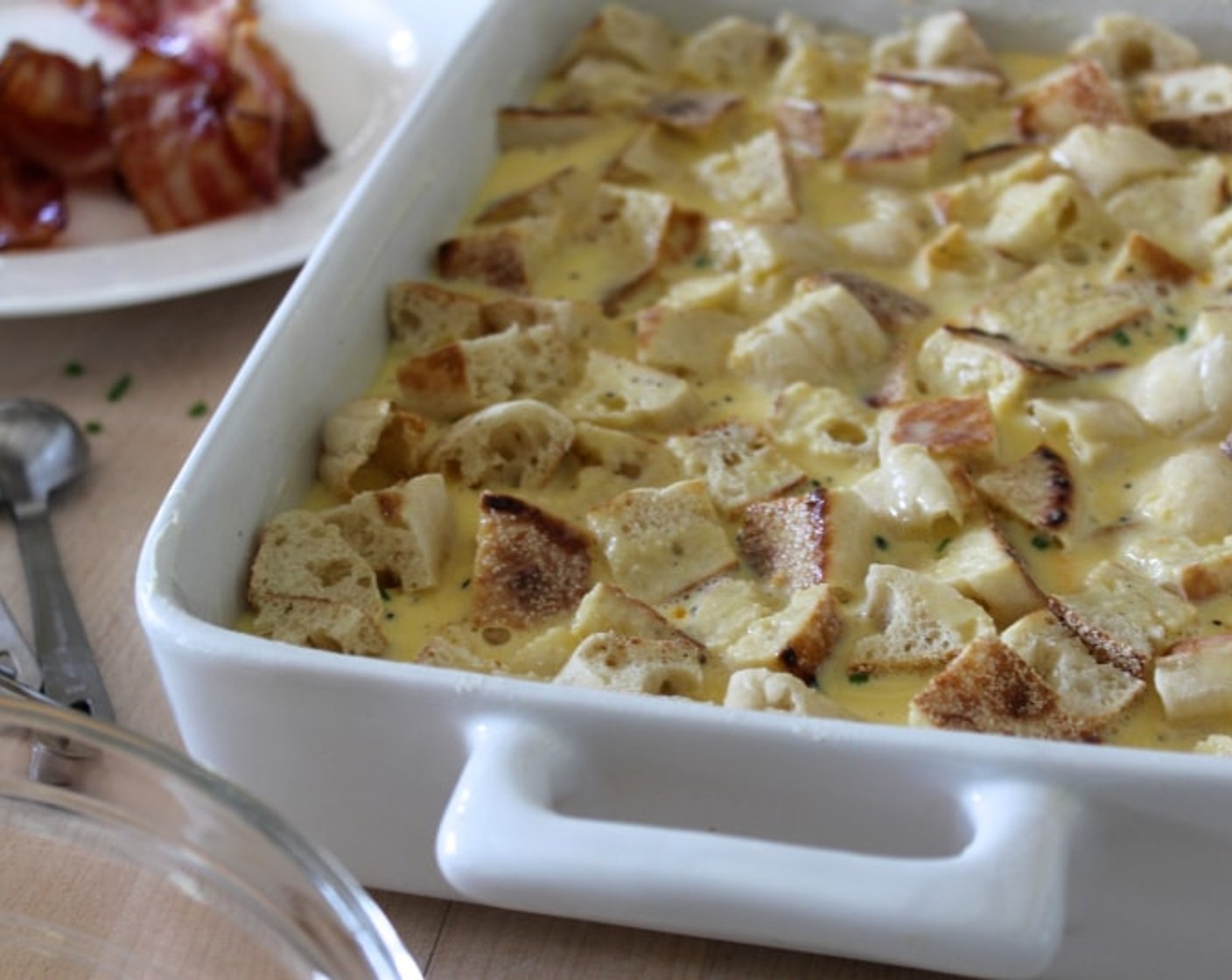 step 8 Carefully pour the egg mixture into the pan, pressing down lightly to make sure all the muffin cubes are moistened. Top with remaining bacon, Sharp Cheddar Cheese (3/4 cup) and Fresh Chives (1 1/2 Tbsp). Wrap well and refrigerate for at least 1 hour, or overnight.