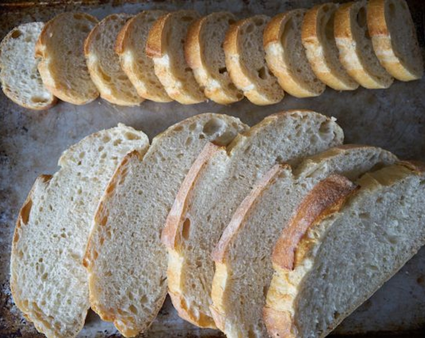 step 2 Slice Bread (1 loaf) – for crostinis, about 1/2 inch thick, for tartines, about 1 inch thick, and lay them out on a sheet pan. Drizzle bread slices with olive oil on both sides.