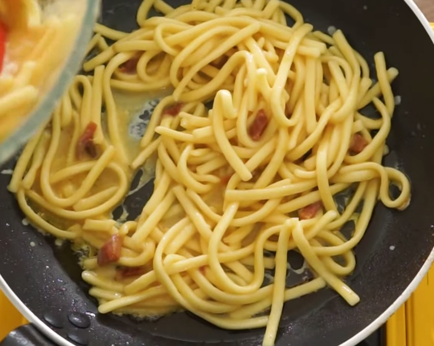 step 10 Place the pan you cooked the guanciale in, back on the stove at medium heat, and add half of the spaghetti frittata mixture to it.