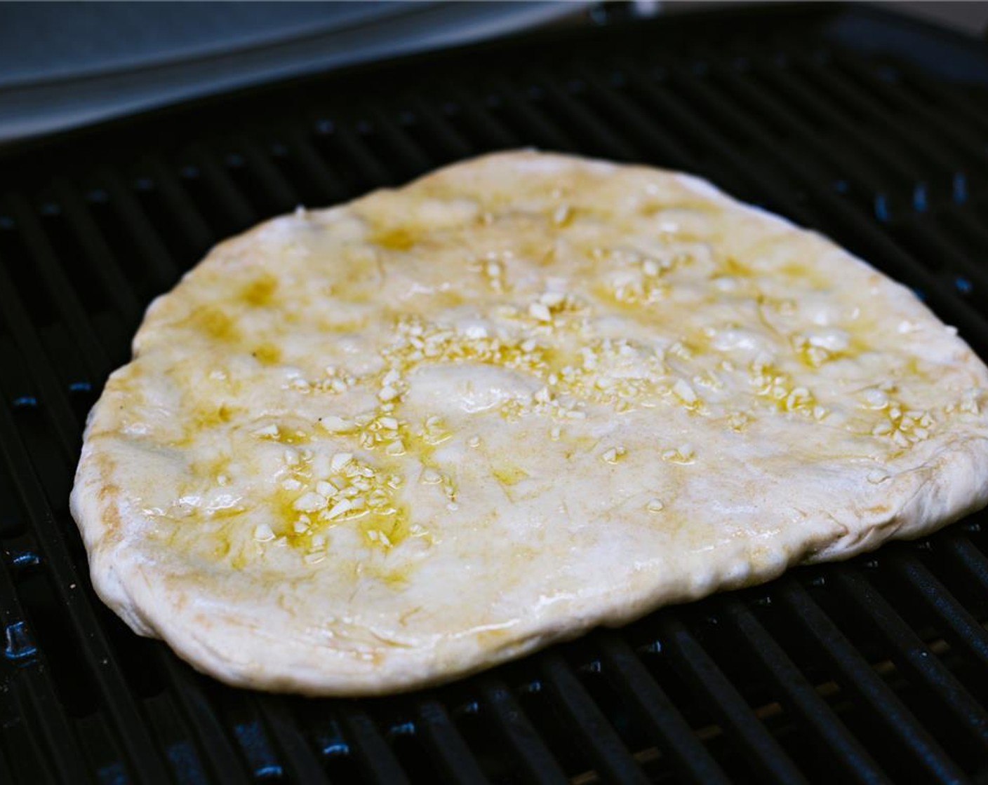 step 6 Brush the remaining Extra-Virgin Olive Oil (2 Tbsp) onto top side and top with the Garlic (5 cloves).