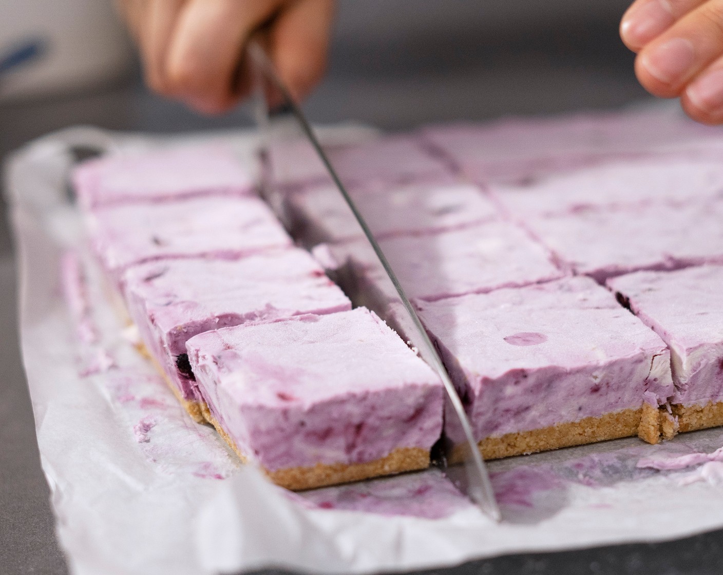 step 7 Use the parchment paper to help unmold, and cut the cheesecake into 2-inch square bars.