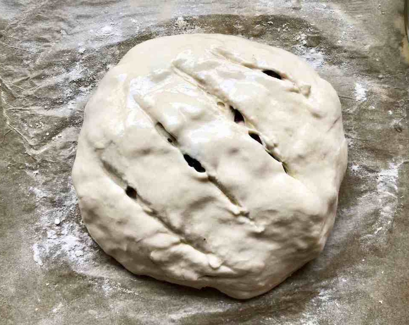 step 11 Paint the surface of the loaf with a cornstarch wash or water. Then cut through the top layer using a serrated bread knife, making three or four 1/2-inch deep slashes.