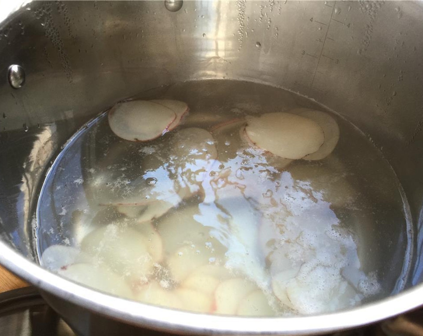 step 8 Once the pot of water is boiling, add a generous pinch of salt to the water. Add the potato slices to the pot. Cook for a minute and remove. Set them on a paper towel lined plate and set aside.