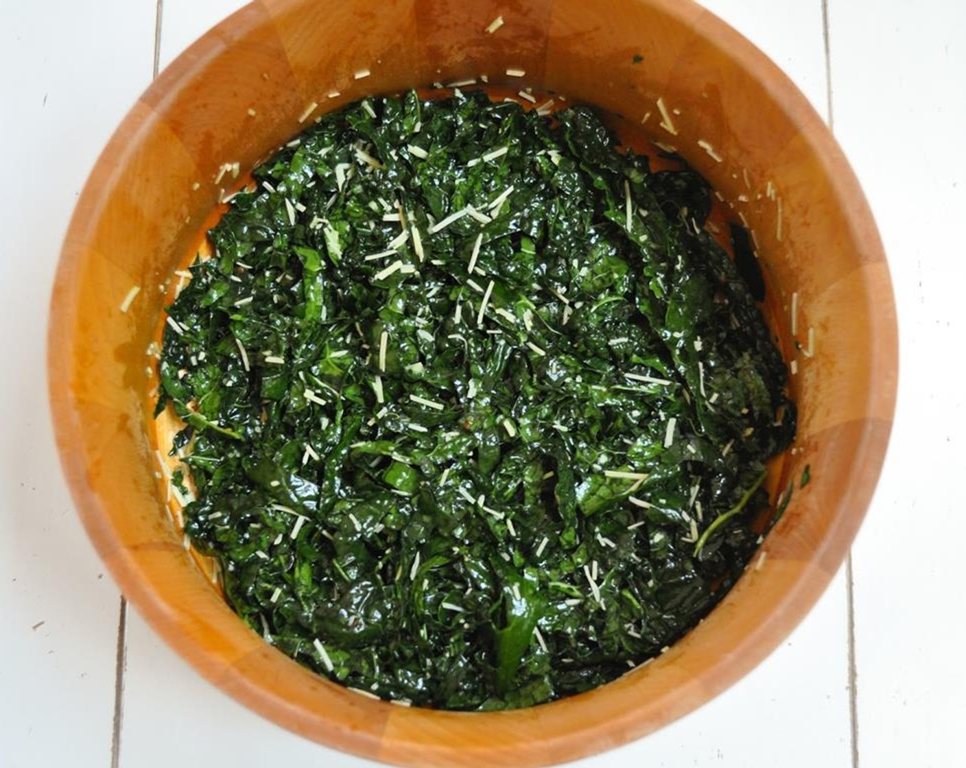 step 4 Pour the dressing over the kale and make sure to massage it well so that all the kale absorbs the dressing. Add grated parmesan and toss.