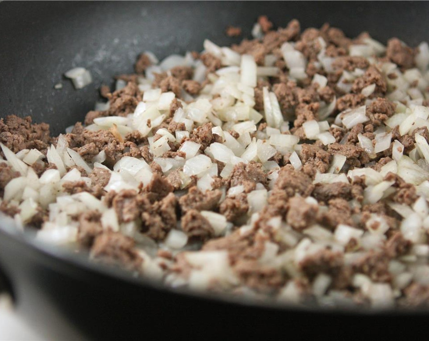 step 3 Cook Ground Beef (1 lb) in a large skillet over medium-high heat until meat is no longer pink. Drain excess grease and add the chopped onion to the skillet.