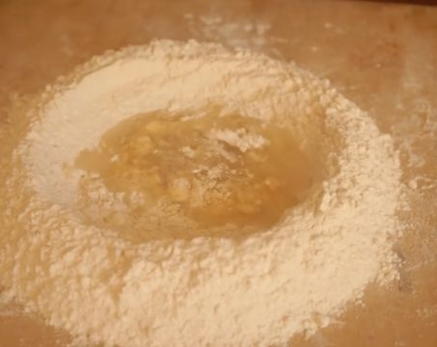 step 1 To start making Pasta e Fagioli you first prepare the sagne pasta dough, so pour flour on your wooden board. Make a mound with the All-Purpose Flour (4 cups) and create a well in the center. Crack the Egg (1) into the well and start whisking it carefully using a fork.