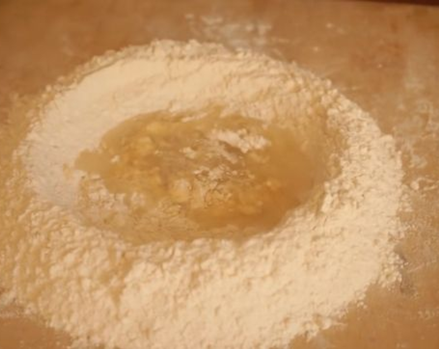 step 1 To start making Pasta e Fagioli you first prepare the sagne pasta dough, so pour flour on your wooden board. Make a mound with the All-Purpose Flour (4 cups) and create a well in the center. Crack the Eggland's Best Classic Egg (1) into the well and start whisking it carefully using a fork.