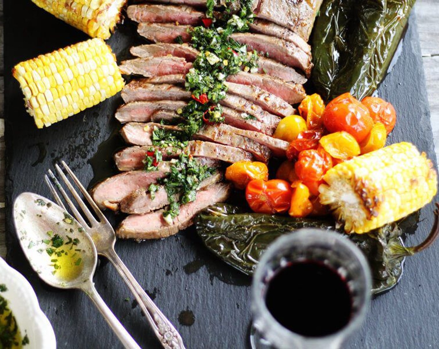 step 9 Transfer the grilled marinated flank steak to a cutting board. Using a serrated knife, slice the flank steaks in thin strips across the grain. Serve warm with roasted vegetables and chimichurri sauce. Enjoy!