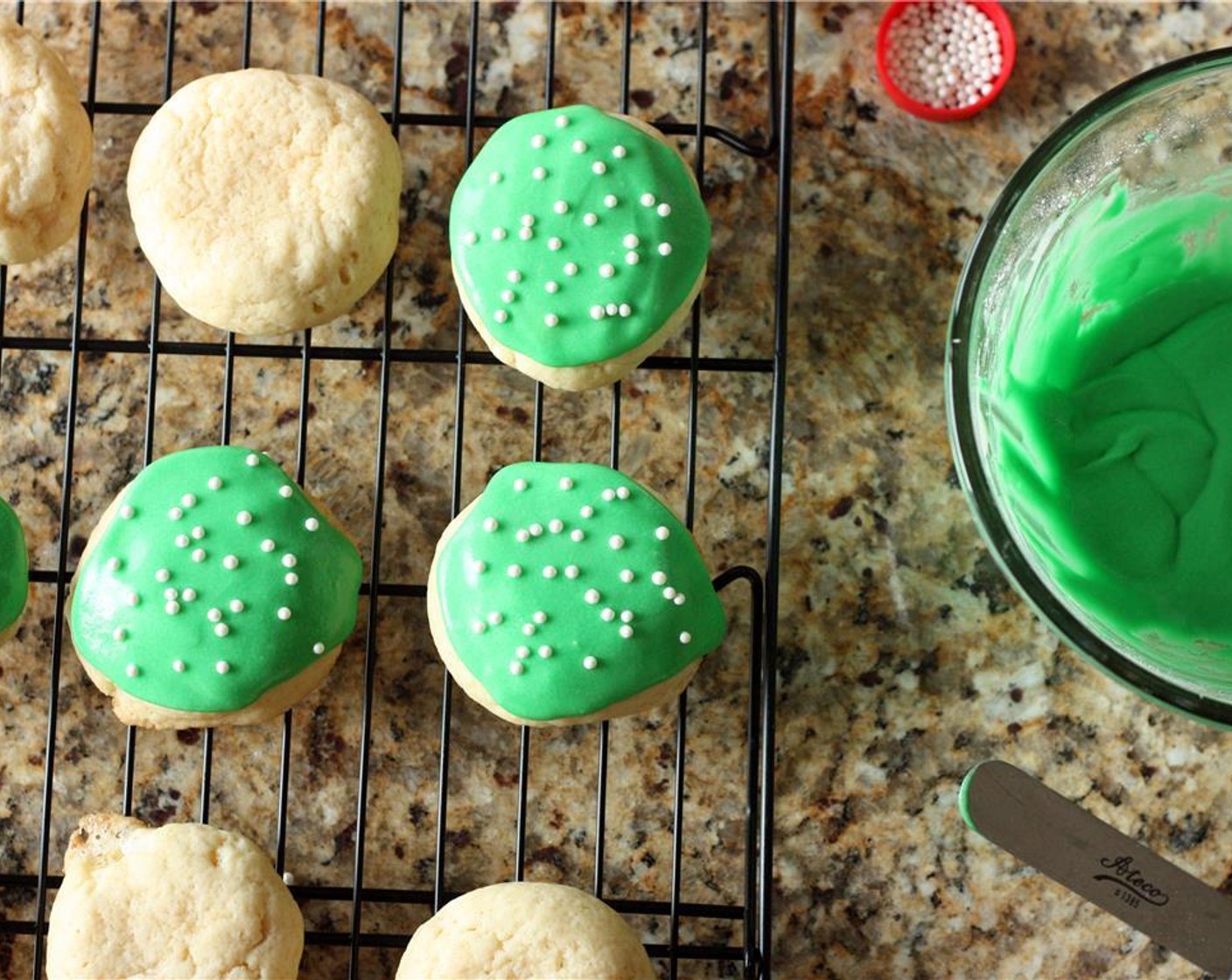 step 10 Spoon a small dollop of icing onto each cookie and spread gently with a knife. If you’re using Sprinkles (to taste), add them now.