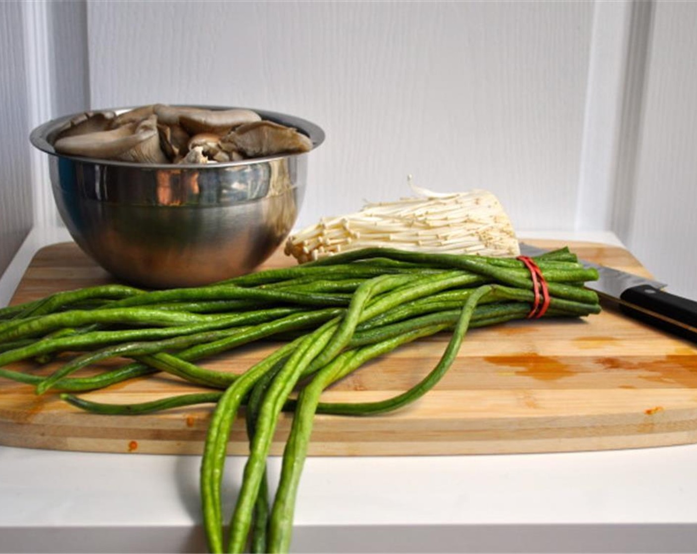 step 2 Cut the Long Beans (1 bunch) into 1 inch pieces. Trim the ends off the Enoki Mushrooms (3 cups) and roughly chop the Oyster Mushrooms (2 cups).