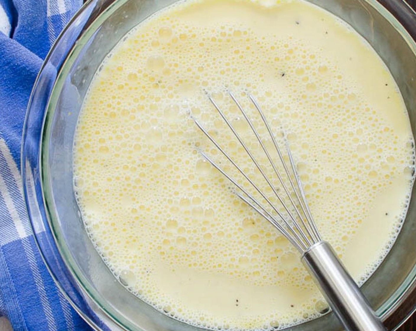 step 4 In a large bowl, combine the Eggs (8), Kosher Salt (1/2 tsp), and Freshly Ground Black Pepper (1/2 tsp). Whisk the eggs, then add the Milk (3 cups) and whisk to combine.