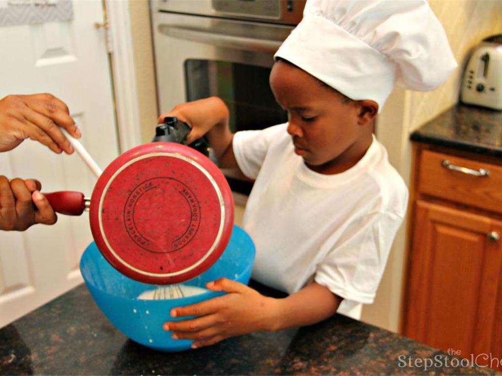Step 6 of Simple Vanilla Soufflé Recipe: Then you add the hot milk to the batter. Here, the Sous Chef or adult helper should help with the hot milk as the little chef slowly whisks the milk into the batter.