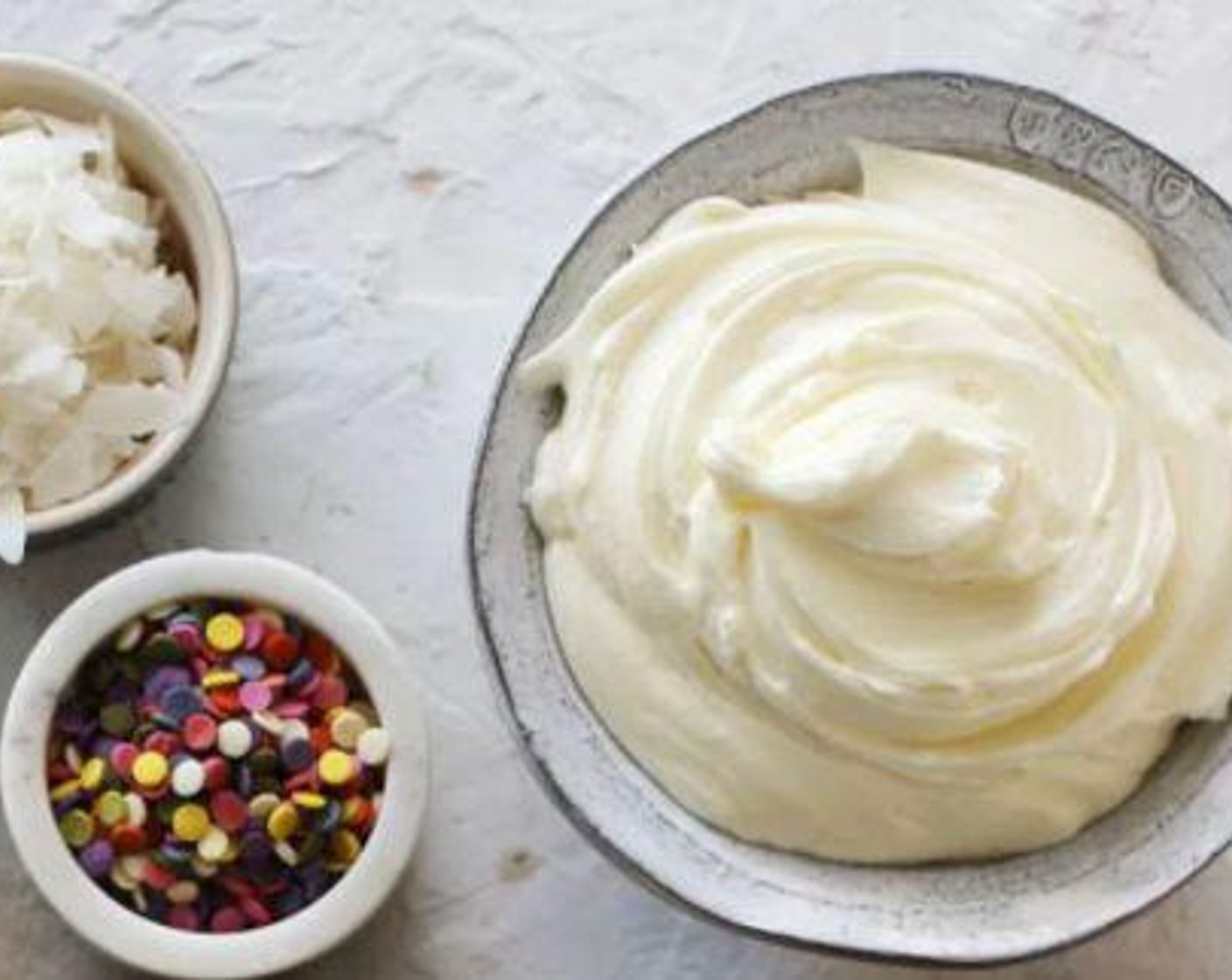 step 7 For the frosting, whip the Butter (1 cup) and Water (1 Tbsp) together for 2 minutes until pale. Add in the Powdered Confectioners Sugar (4 cups), Coconut Extract (1 tsp), and Heavy Cream (1 Tbsp) and whisk on low.