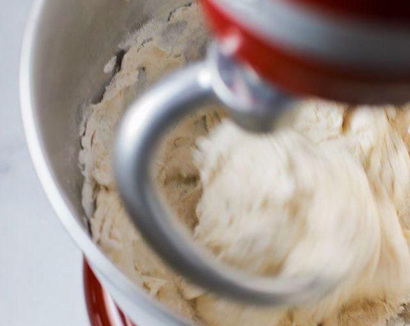 step 4 Mix dough on low speed with a dough hook attachment on the mixer. Mix for at least 7 minutes and up to 10 minutes if still not combined well at the end. The dough should be a bit tacky but come off the dough hook easily.