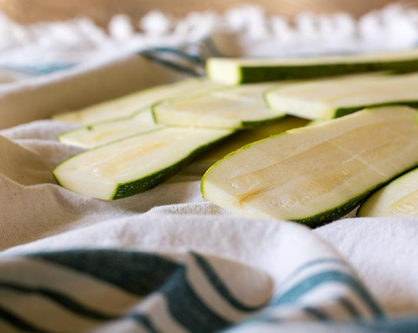 step 1 Slice Zucchini (2) into long thin strips, then lay out on fresh paper towels and coat with layer of salt, then let them sit for about 15 minutes. This helps to sweat the water out. After the 15 minutes, apply pressure with a paper towel to remove some of that moisture.