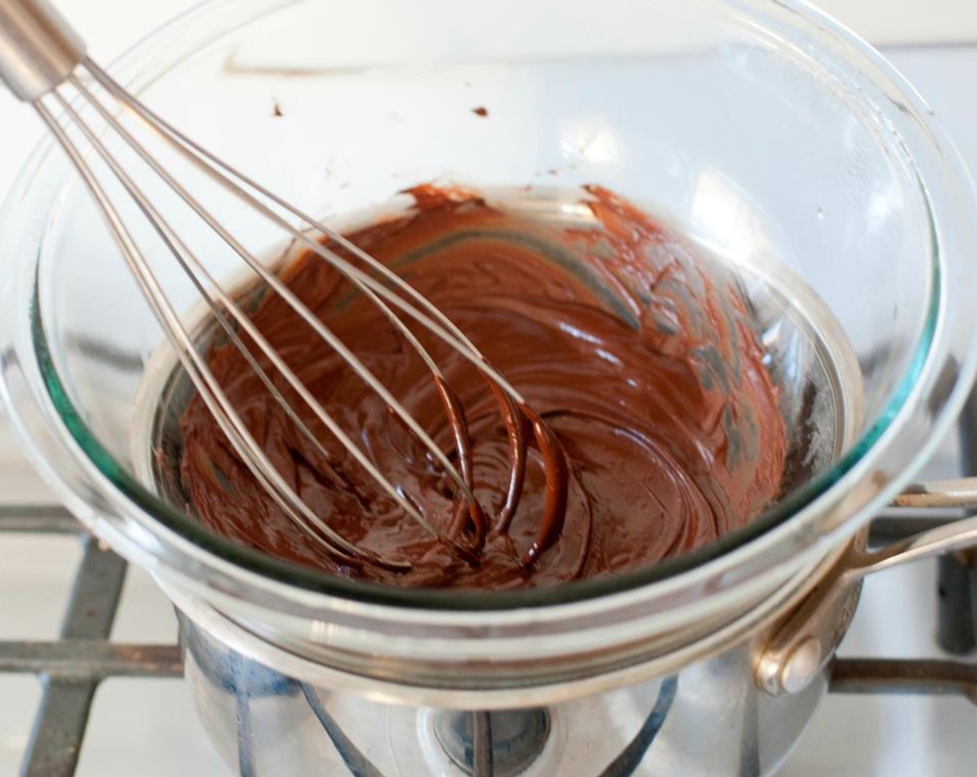 step 2 Place a small stovetop-safe bowl inside the pot and turn the heat down to low, just enough to keep the water boiling. Add the Dark Chocolate Chunks (4 Tbsp) and whisk intermittently, erasing any clumps and ensuring it doesn't burn.