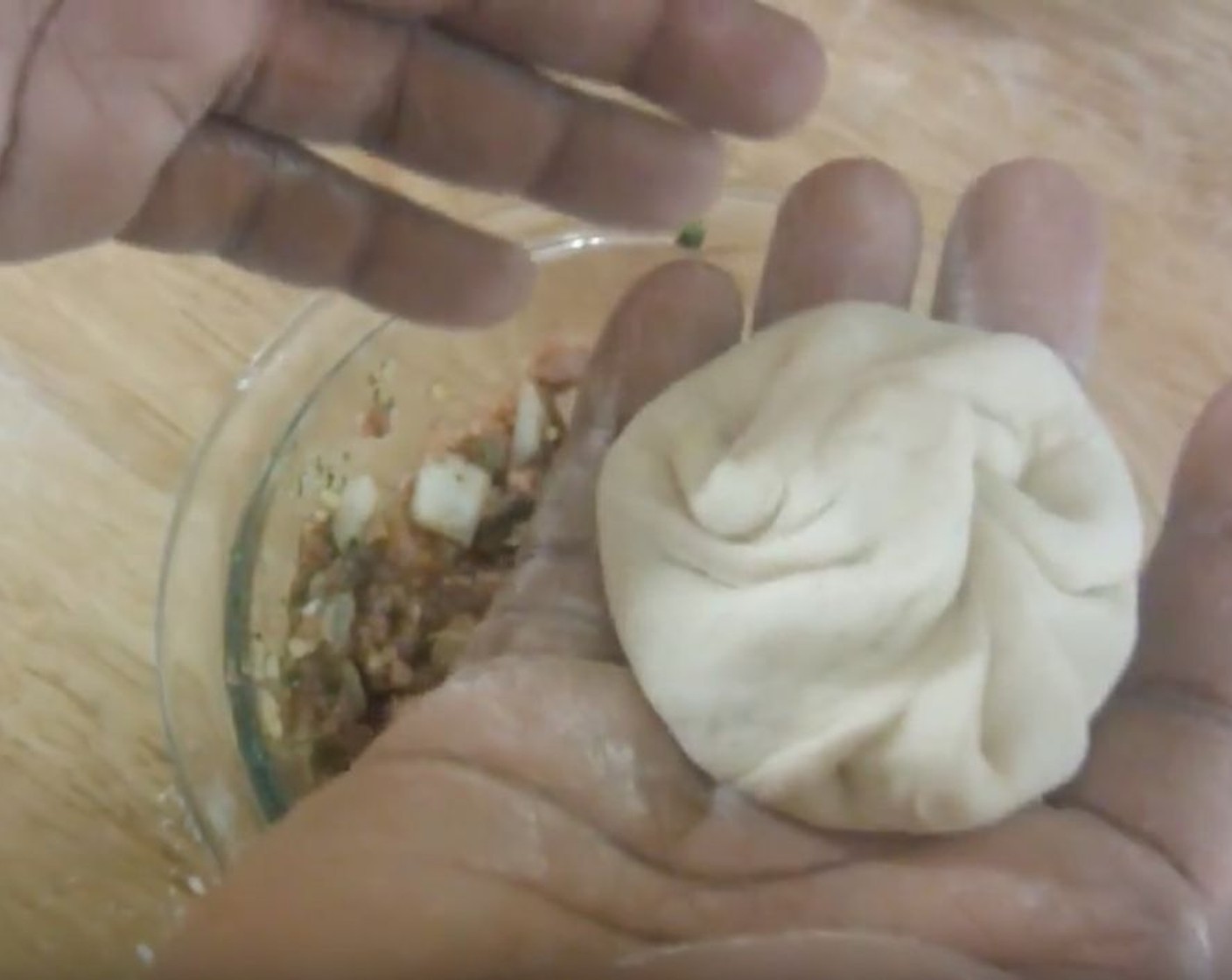 step 7 Into each circle of dough, add about 1 1/2 tablespoons of filling. Crimp the edges and pinch them together, going all the way around. Pinch the top to close, then twist it and press down lightly.